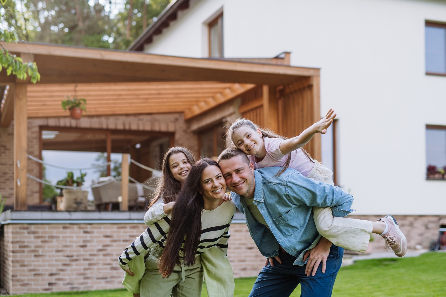Familie mit zwei Kindern vor Haus
